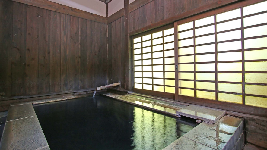 【石風呂】庭の緑が窓からこぼれる石風呂。石で出来た重厚な石風呂は冷たいようで温もりあるお風呂。