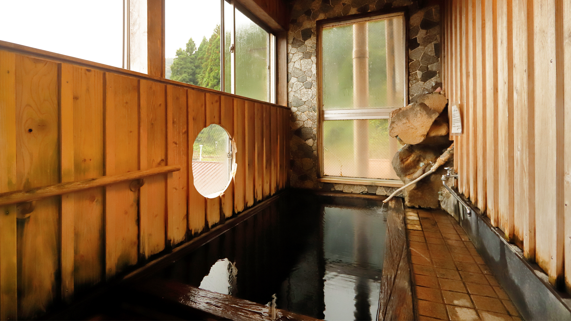 【陽の湯】4階の展望貸切風呂。陽のエネルギーが満ち、浴槽には備長炭が練りこまれている。純重曹泉。