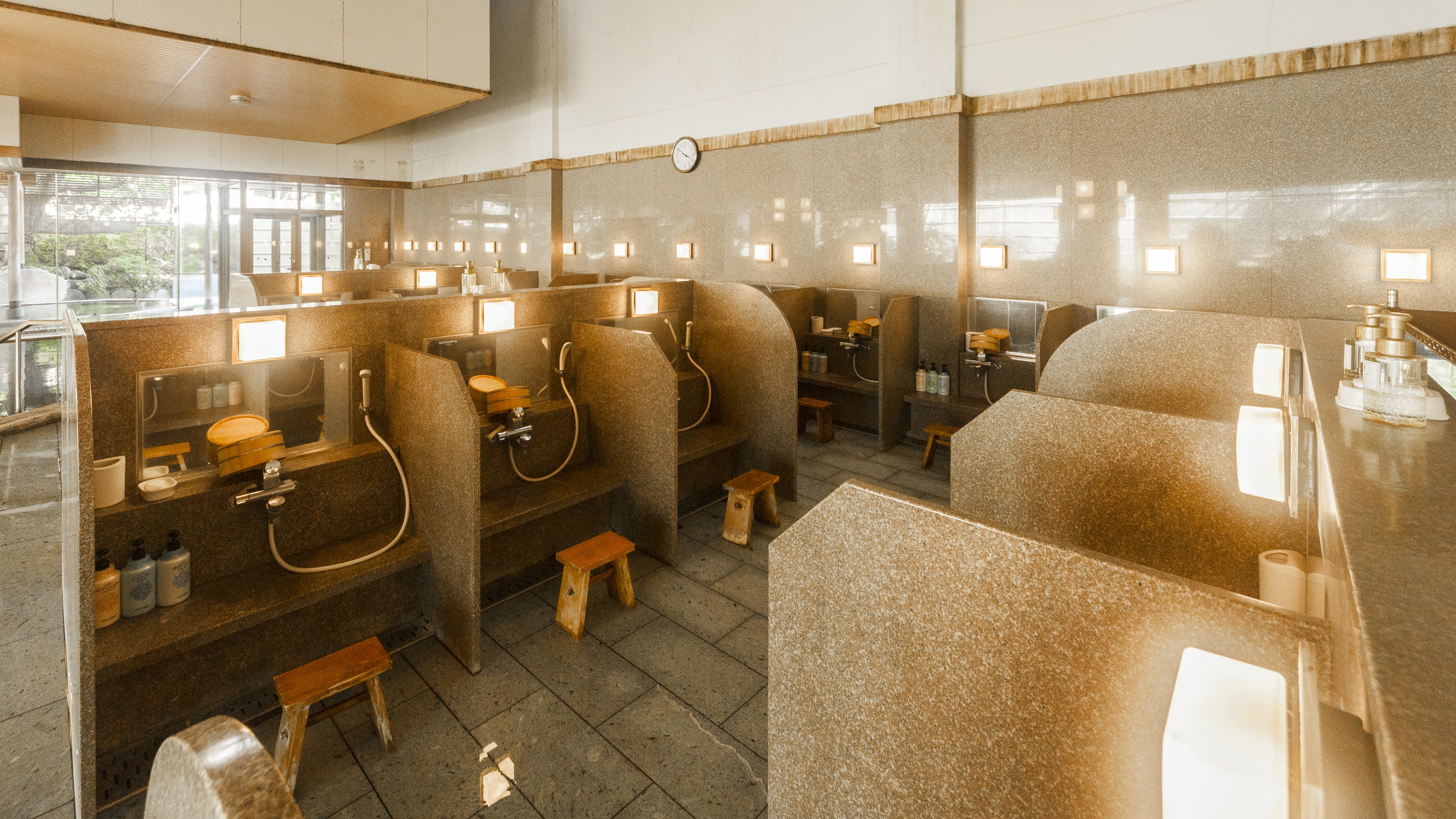 大浴場洗い場。ブースの数が多く人目を遮る仕切りがございます。