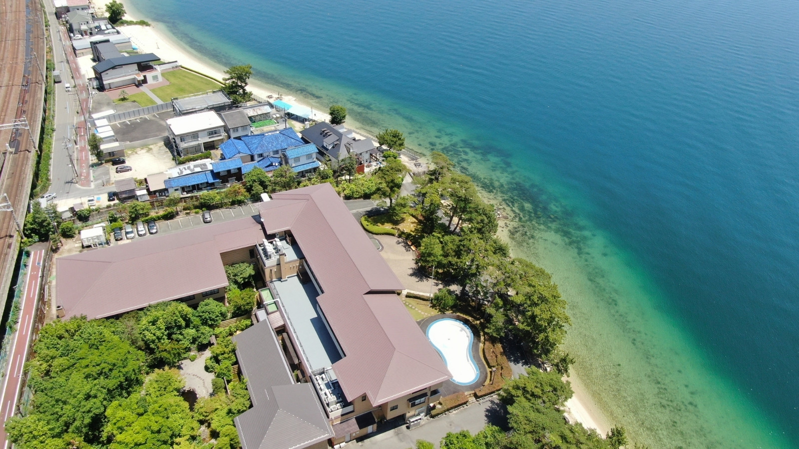 【外観】比良山系を背景に白砂青松と透明度抜群の琵琶湖が素晴らしい場所に佇む宿。