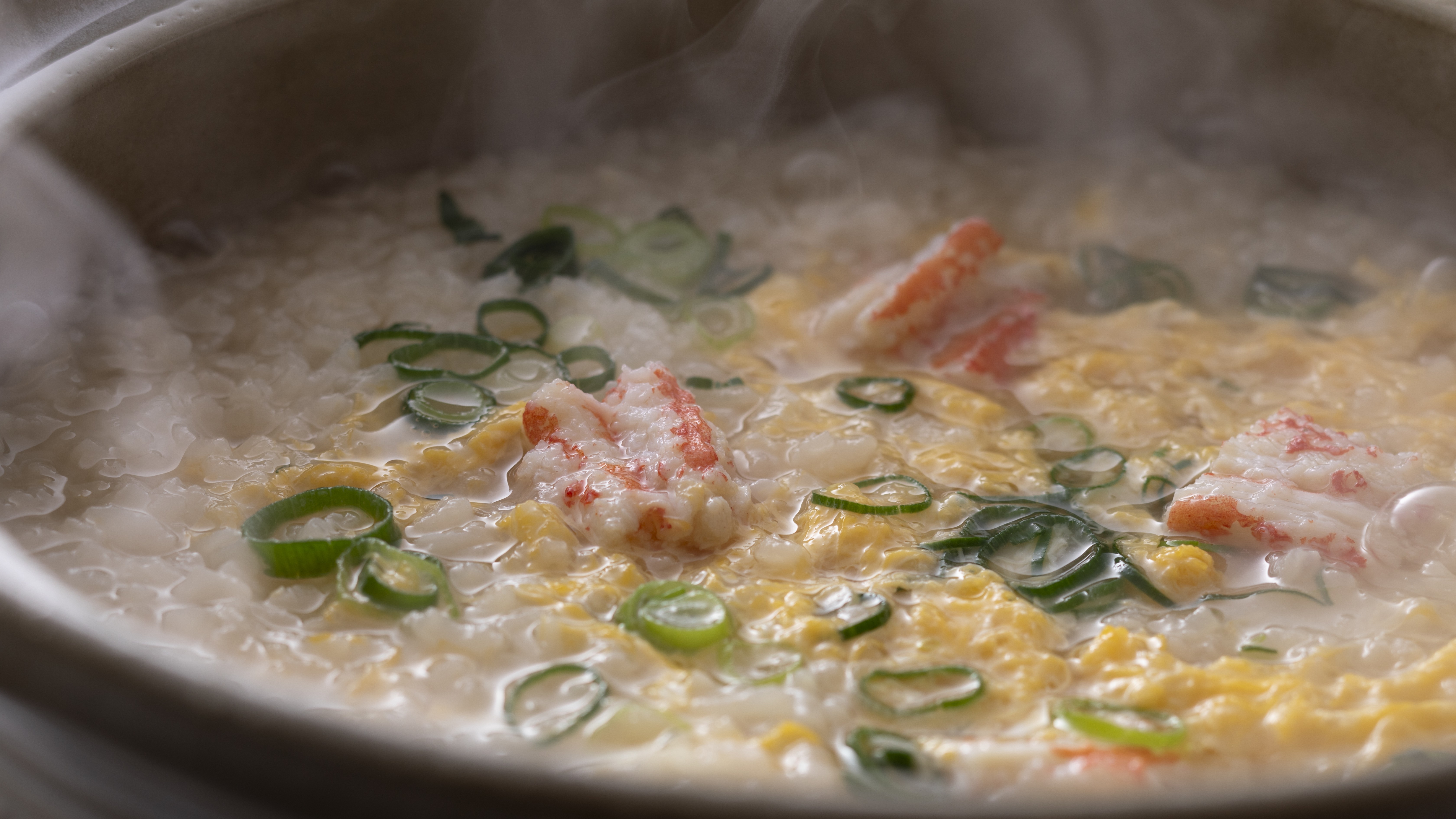 【冬のお料理】カニ雑炊は、カニの旨味たっぷりの出汁にご飯と卵が絡む、心温まる贅沢な締めの一杯（一例）