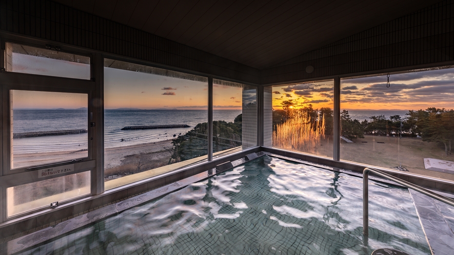 【大浴場－男湯】二面に広がる窓から、美しい朝陽がご覧いただけます。