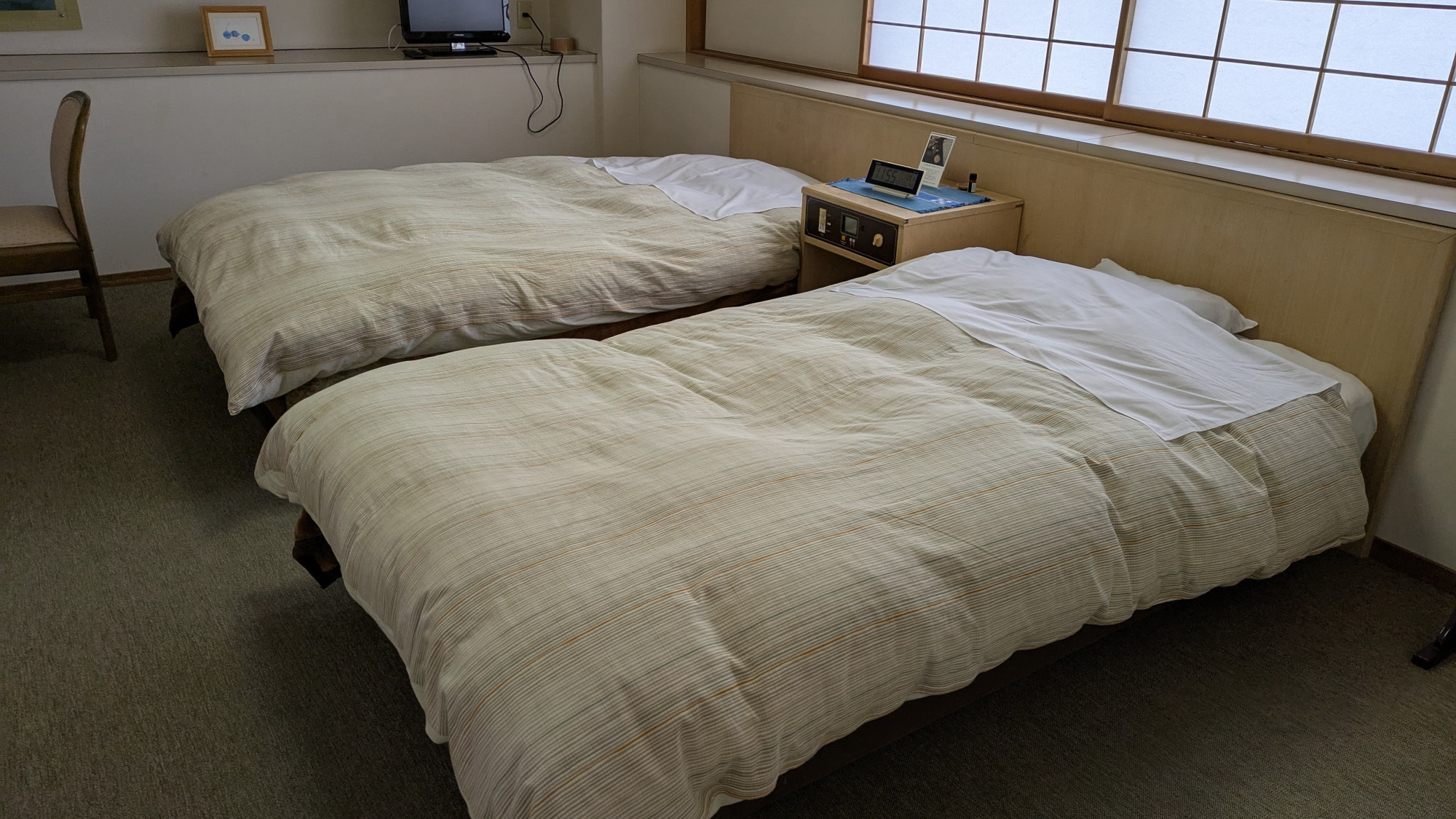 【別館／すみれの間】ツインベッドを備えた洋室。窓からは景色をご覧いただけます。