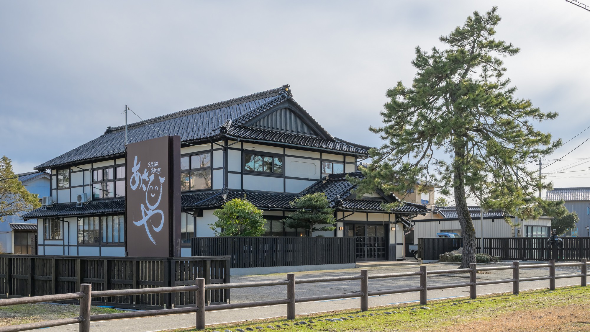 【外観】大きな松の木とにこにこ笑顔の看板が目印「浜辺の宿　あさひや」です。