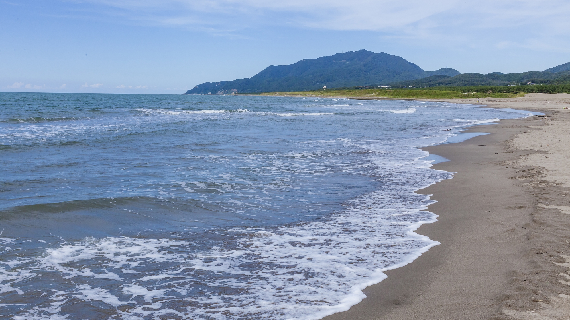 波打ち際から弥彦山を望む