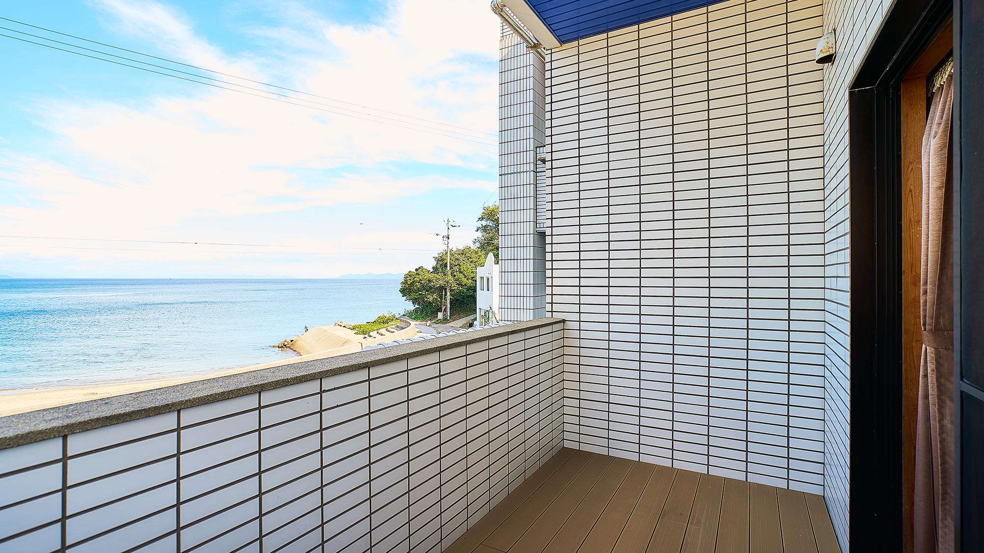 ・【客室／風】バルコニーのすぐ向こうに海が広がります。海風と波音を楽しみながらお寛ぎください