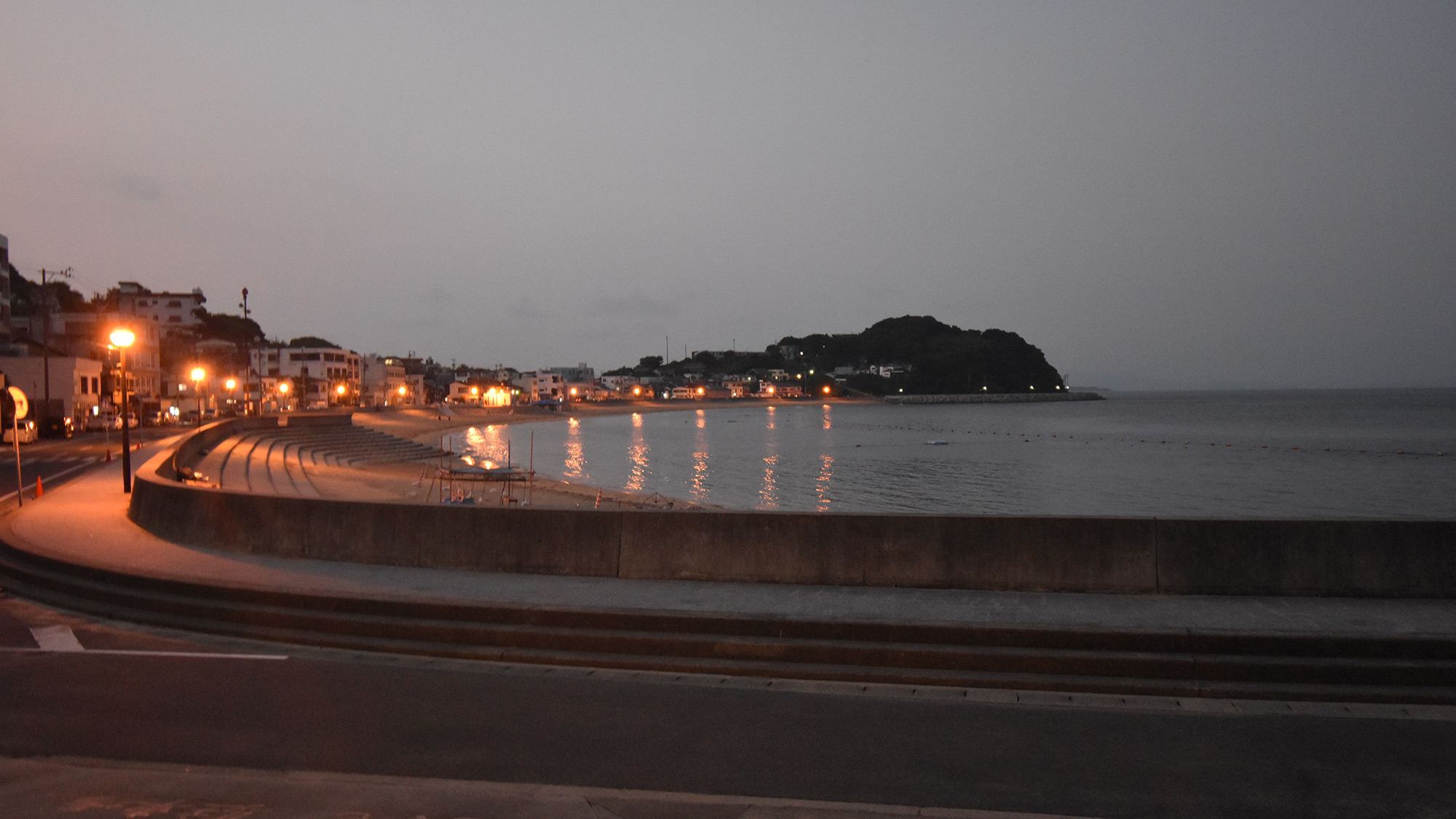 ・【夜の海水浴場】水面に輝く街灯の光が異なる表情を見せます
