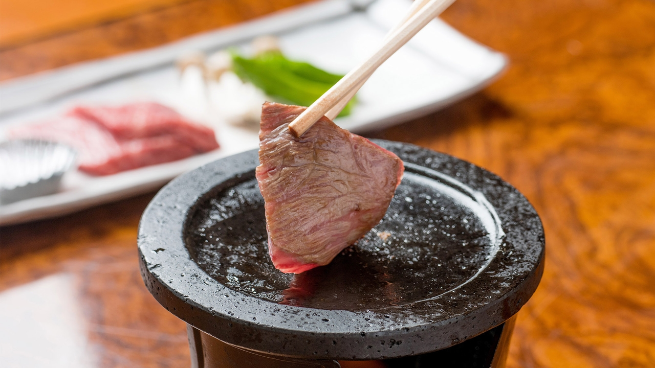 肴屋本店の常陸牛の石焼き。熱い石の上で肉を焼くところ