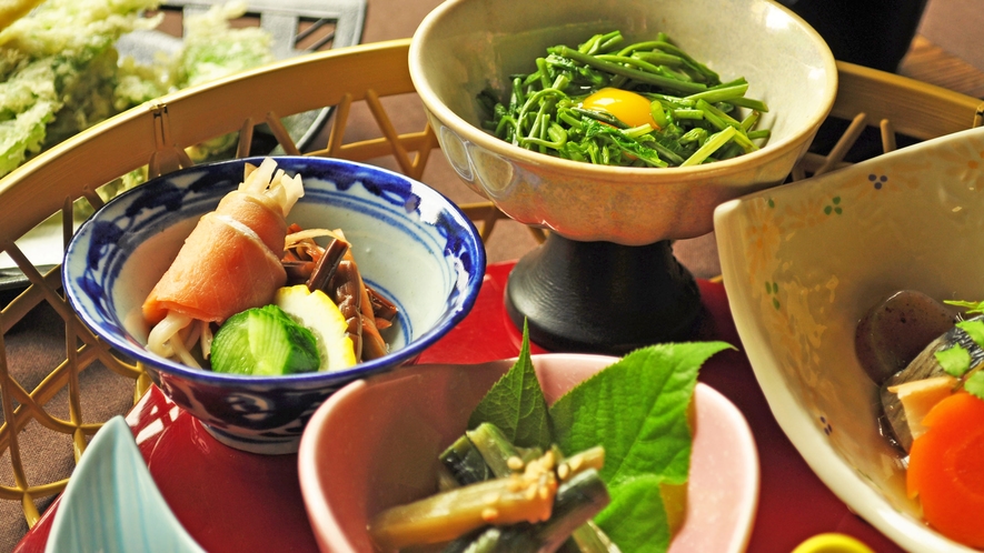 【夕食一例】（左）ワラビとスモークサーモンの酢の物・（右）アケビの新芽