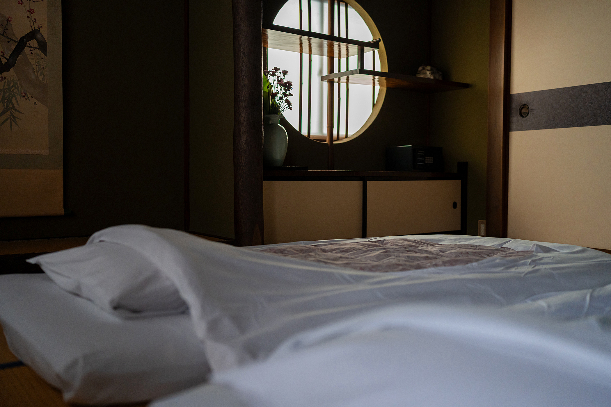 【和室12畳トイレ付】布団に寝転んで見上げる丸窓