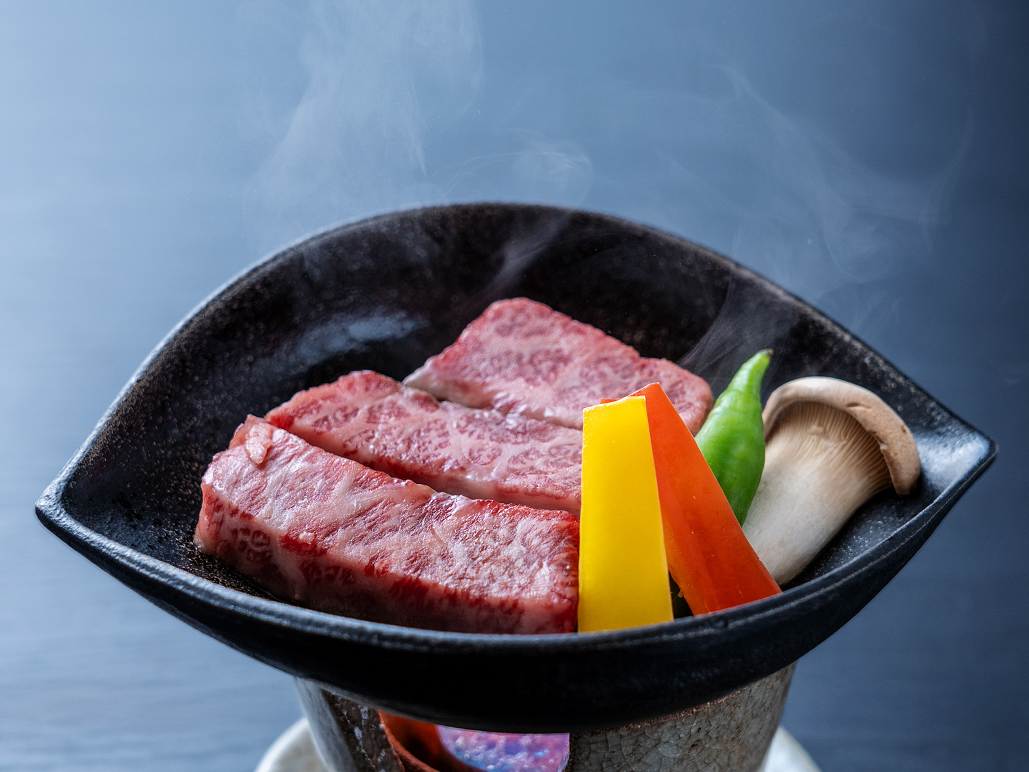 ジューッと音を立てる陶板焼き。香ばしい香りが食欲をそそる国産牛