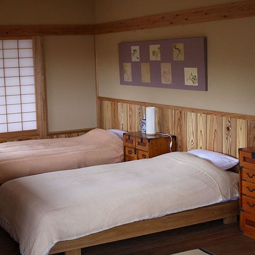 ツインベッドのベッドルームは落ち着いた作り