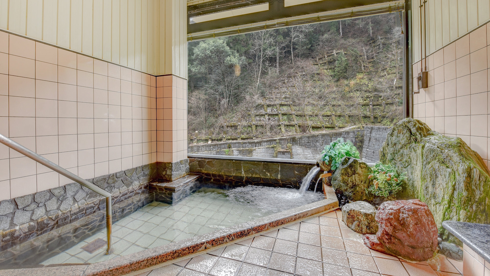 *大浴場　男女入れ替え/渓流沿いに建つ当館。清涼感のある景色が、窓から楽しめます。