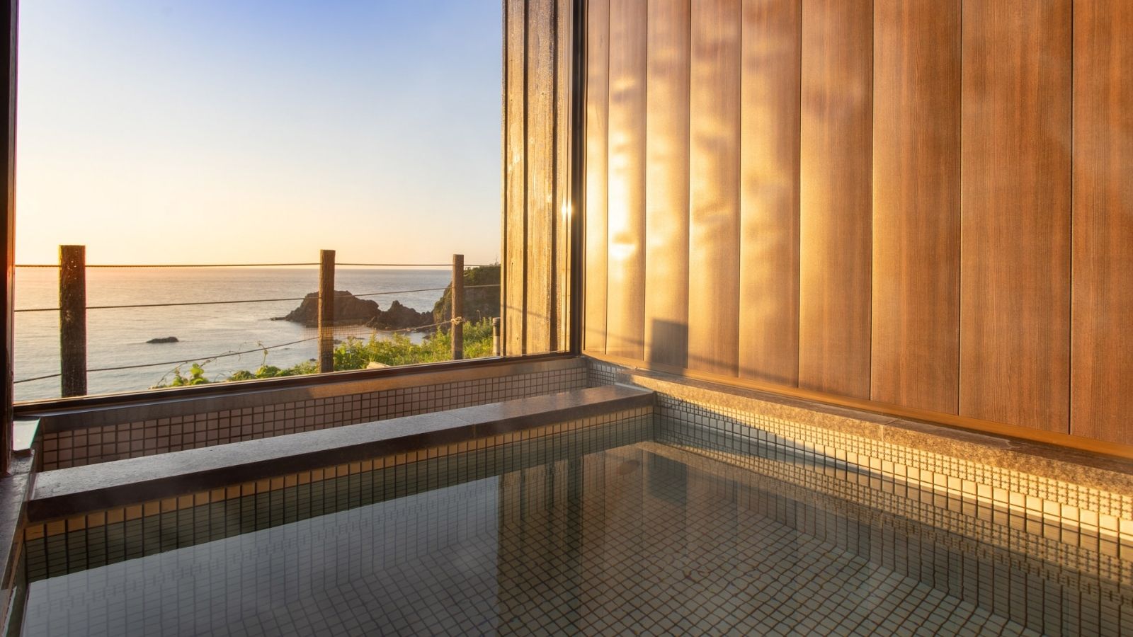 海を望む贅沢な露天風呂。夕日に照らされながら、心ゆくまでリラックスできる至福のひととき
