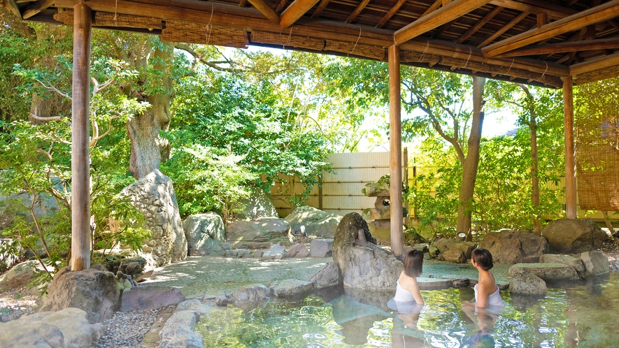 すだれから降り注ぐ木漏れ日と岩の感触が心地よい庭園露天風呂。