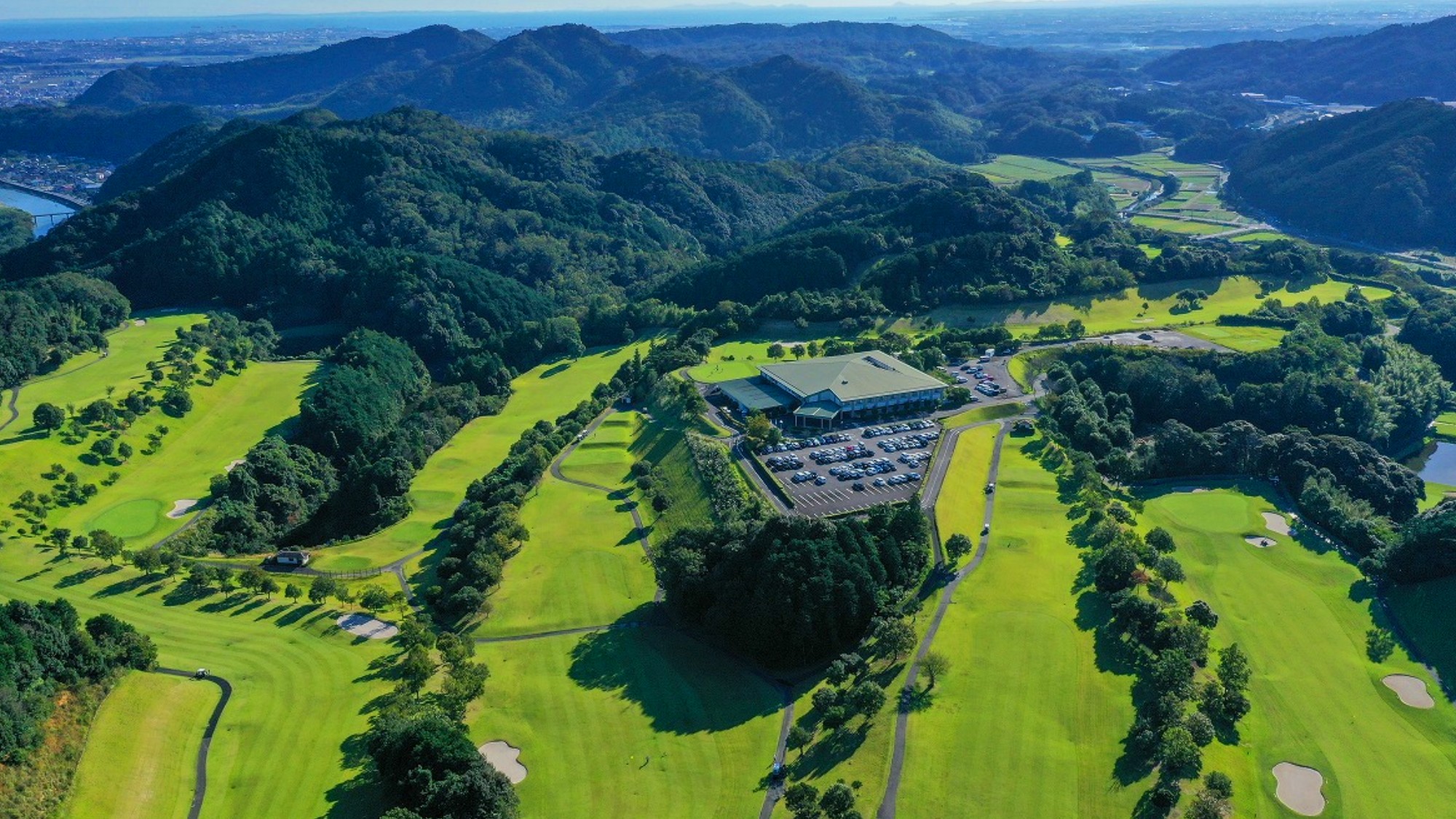 山並みに抱かれた広大なグリーン。心と体を解き放つ、非日常の開放感。