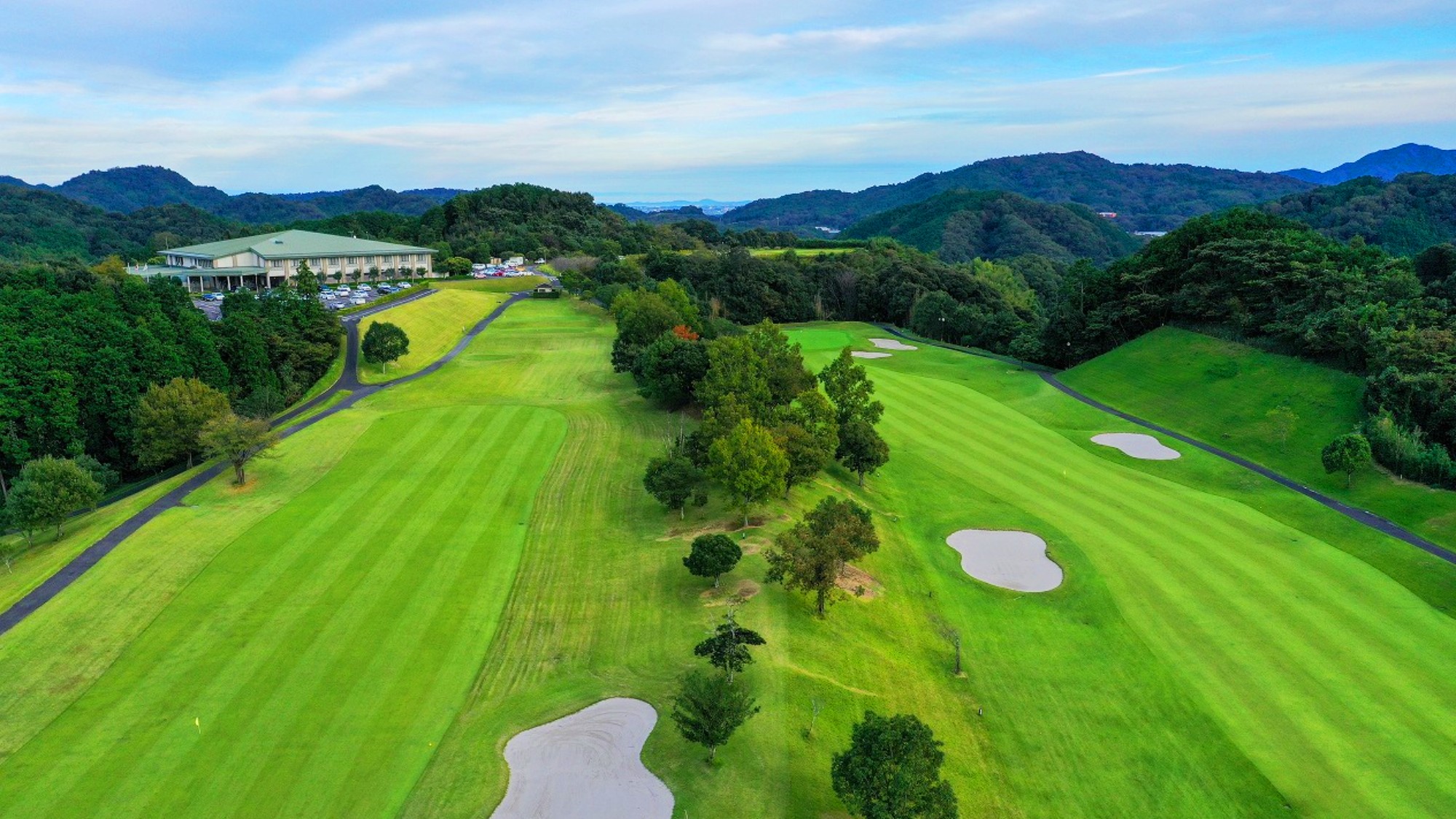 山並みに抱かれた広大なグリーン。心と体を解き放つ、非日常の開放感。
