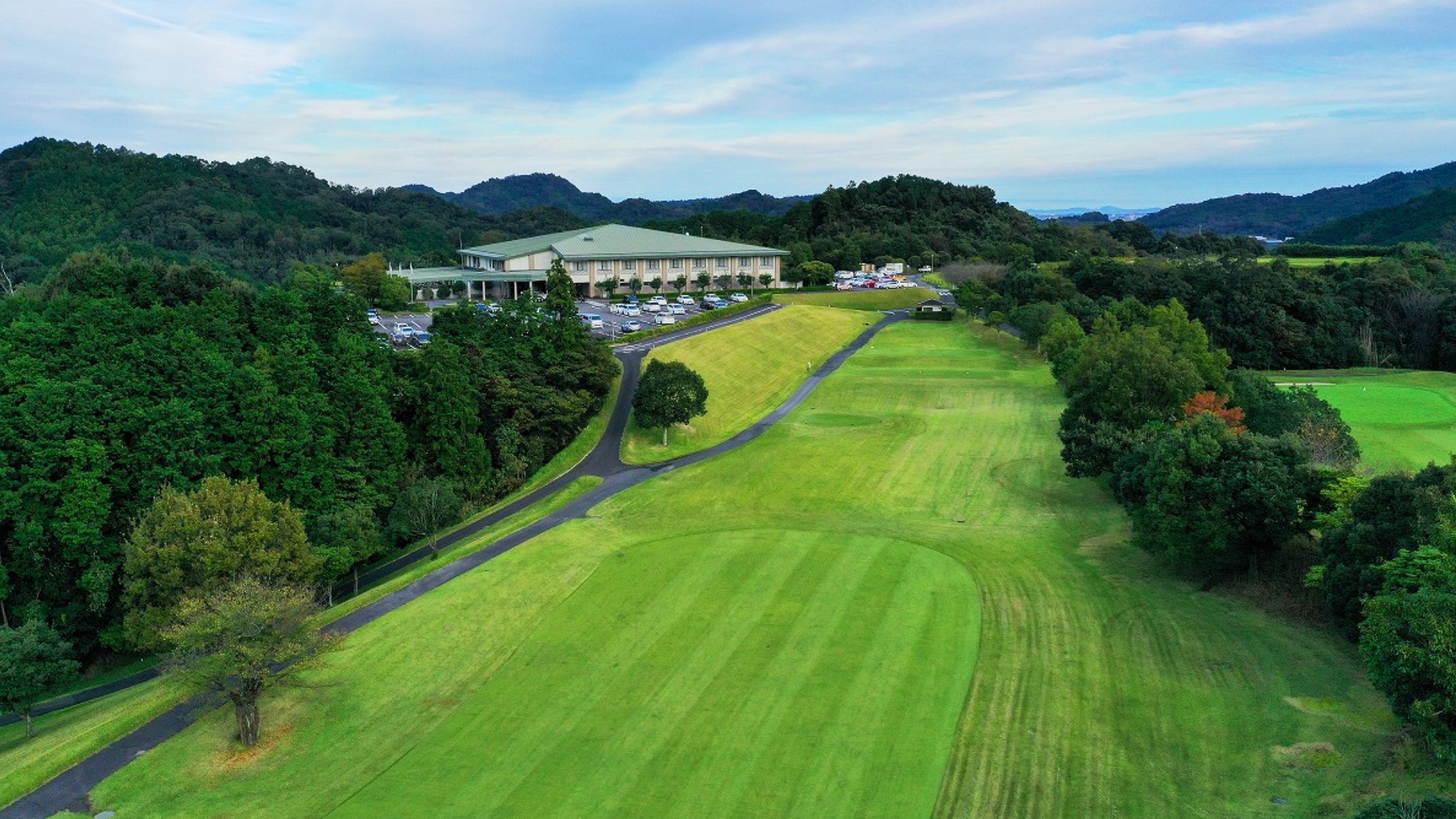 山並みに抱かれた広大なグリーン。心と体を解き放つ、非日常の開放感。