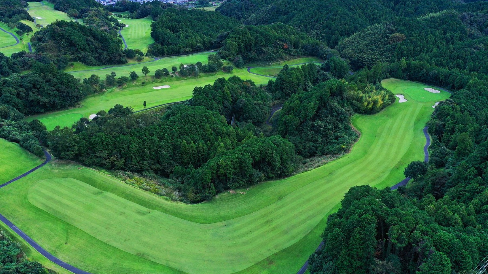 山並みに抱かれた広大なグリーン。心と体を解き放つ、非日常の開放感。