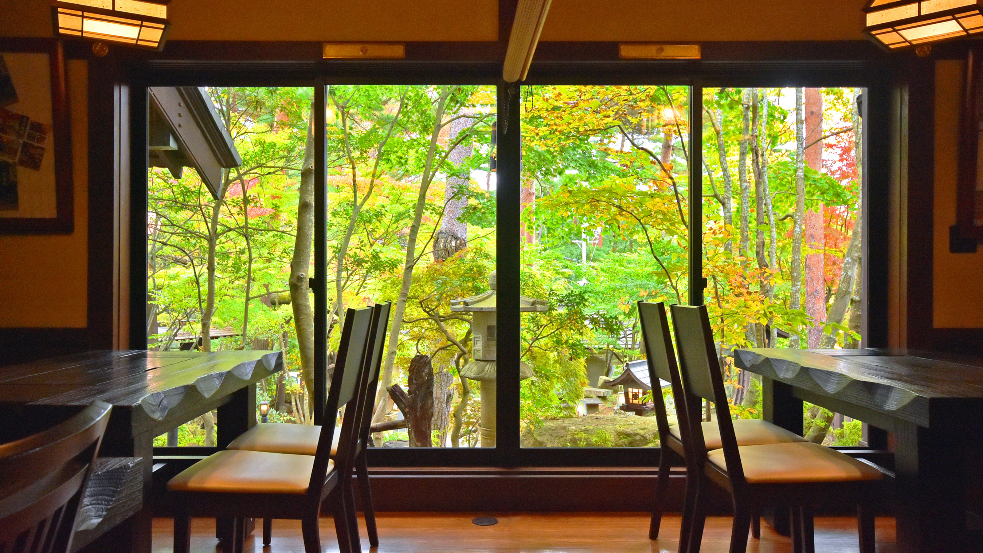 【館内】食事処の一階。秋に色づく樹々を切り取る窓の景色はまるで絵画のよう