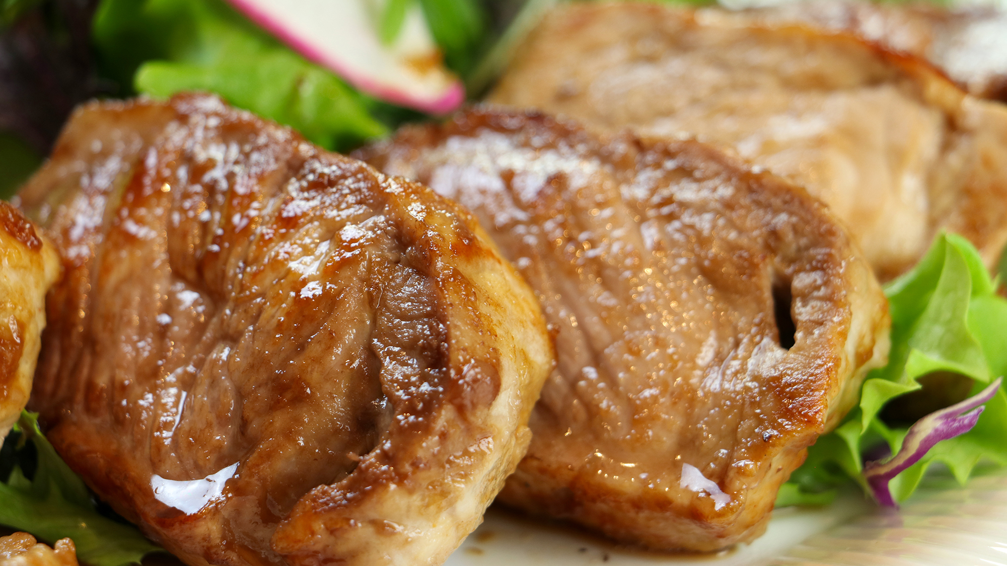 #厚くカットされた三元豚のステーキをオリジナルのソースとともに