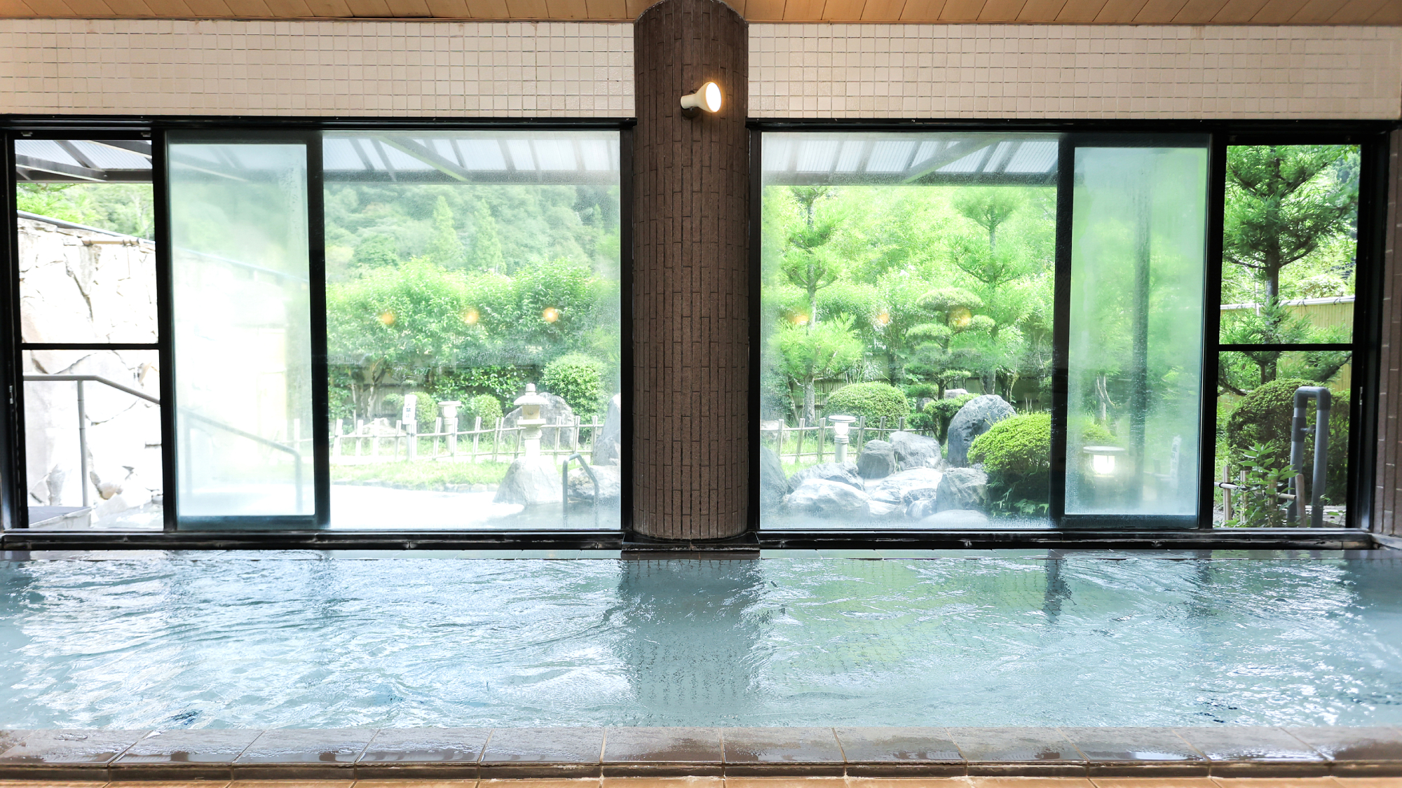 大浴場｜窓から外の風景を楽しむ、広々とした内湯風呂。