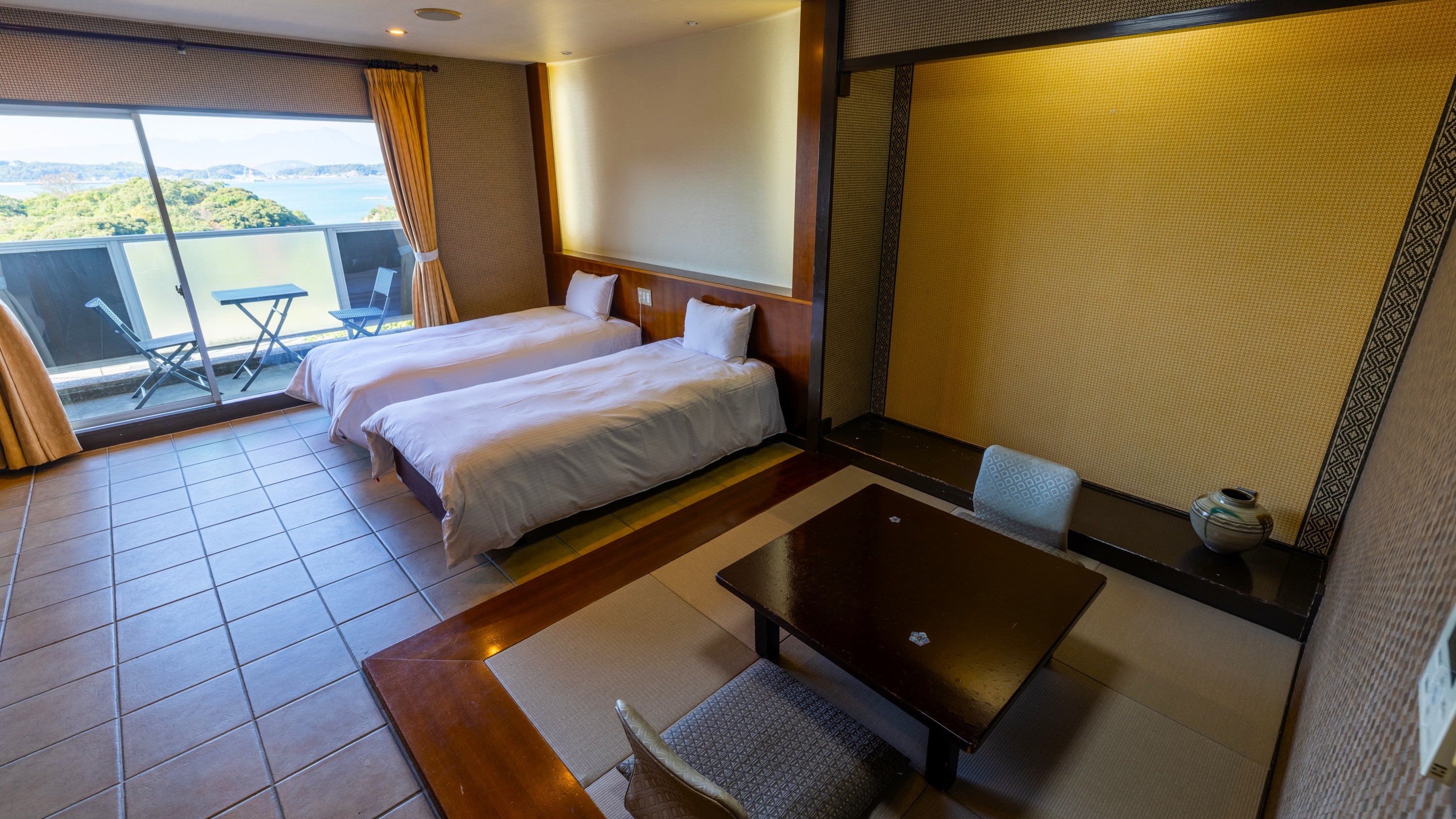 【客室】和洋室：琉球畳のスペースとベッドスペース。ソファもあるので過ごしやすい空間です。