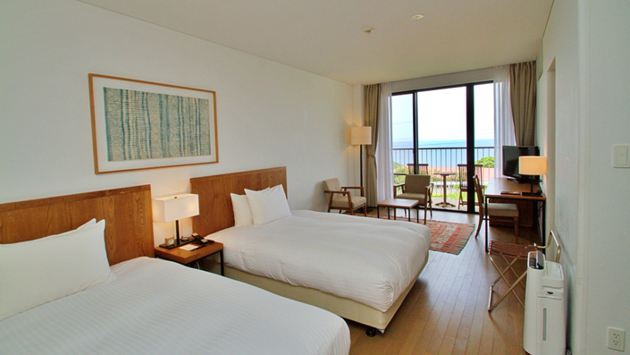 落ち着きある木目調のデラックスルーム。客室備え付けのお風呂からも外の景色をご覧いただけます。