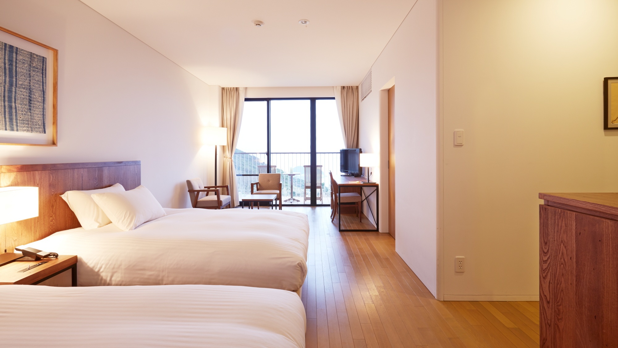 落ち着きある木目調のデラックスルーム。客室備え付けのお風呂からも外の景色をご覧いただけます。