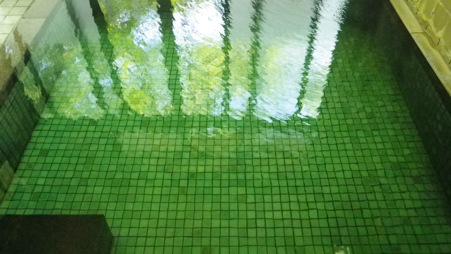 *温泉大浴場（一例）日によってお湯の色がエメラルドグリーンに変化します。