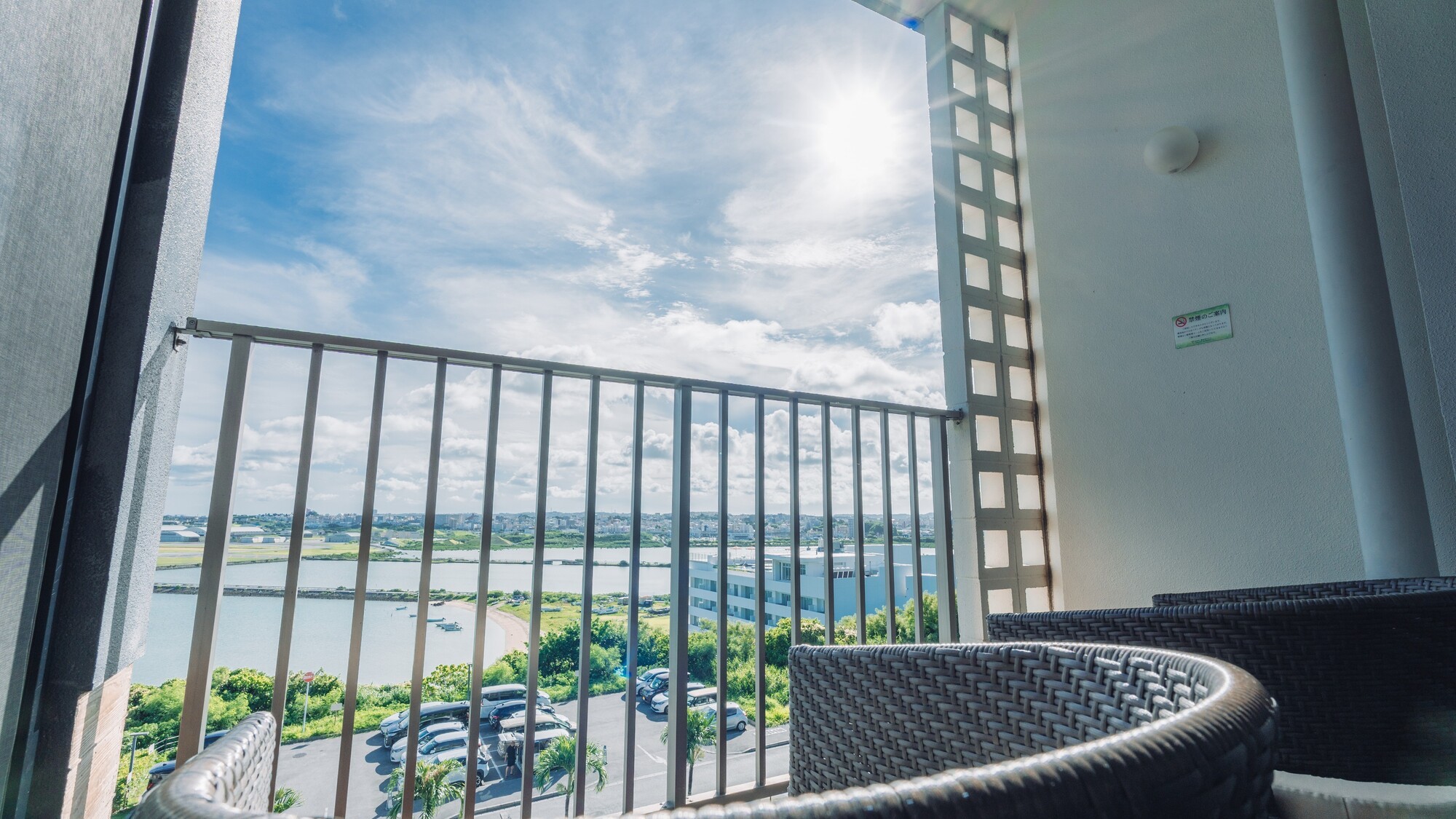 チェアに腰掛け、沖縄の眩しい光とダイナミックなエアポートビュー