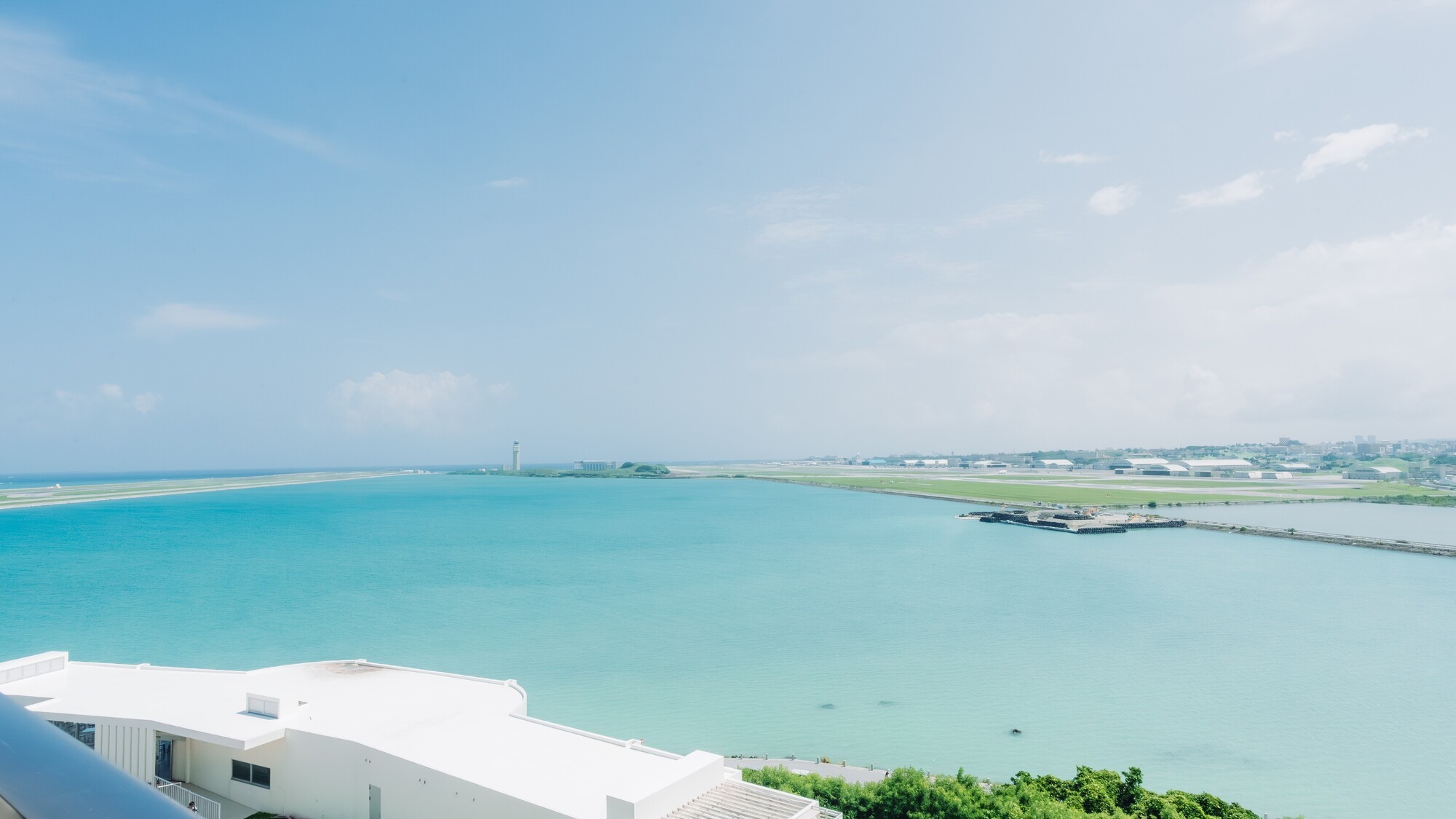 眼下に広がるエメラルドグリーンの海と那覇空港滑走路