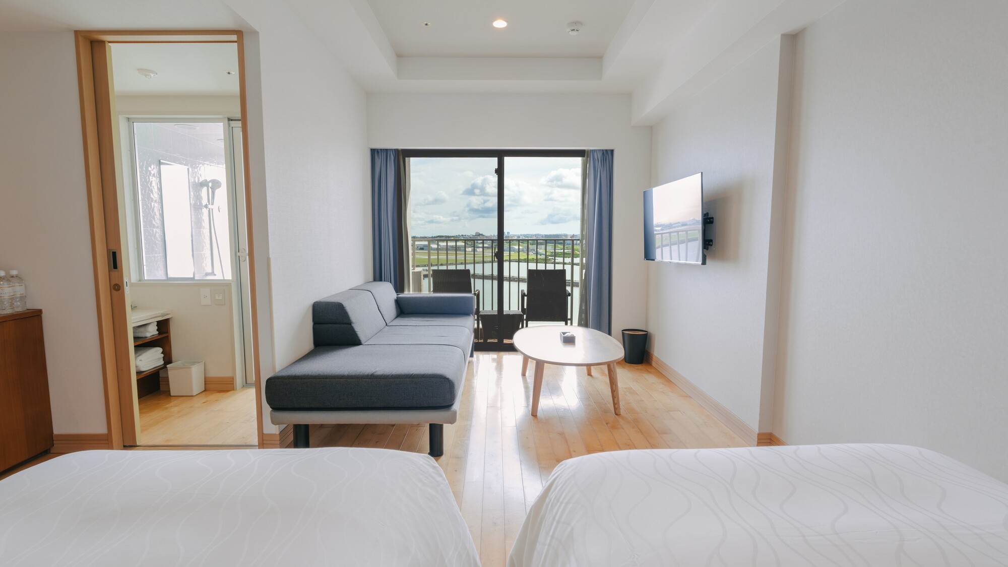 大きな窓とバルコニーの向こうには青い海と空