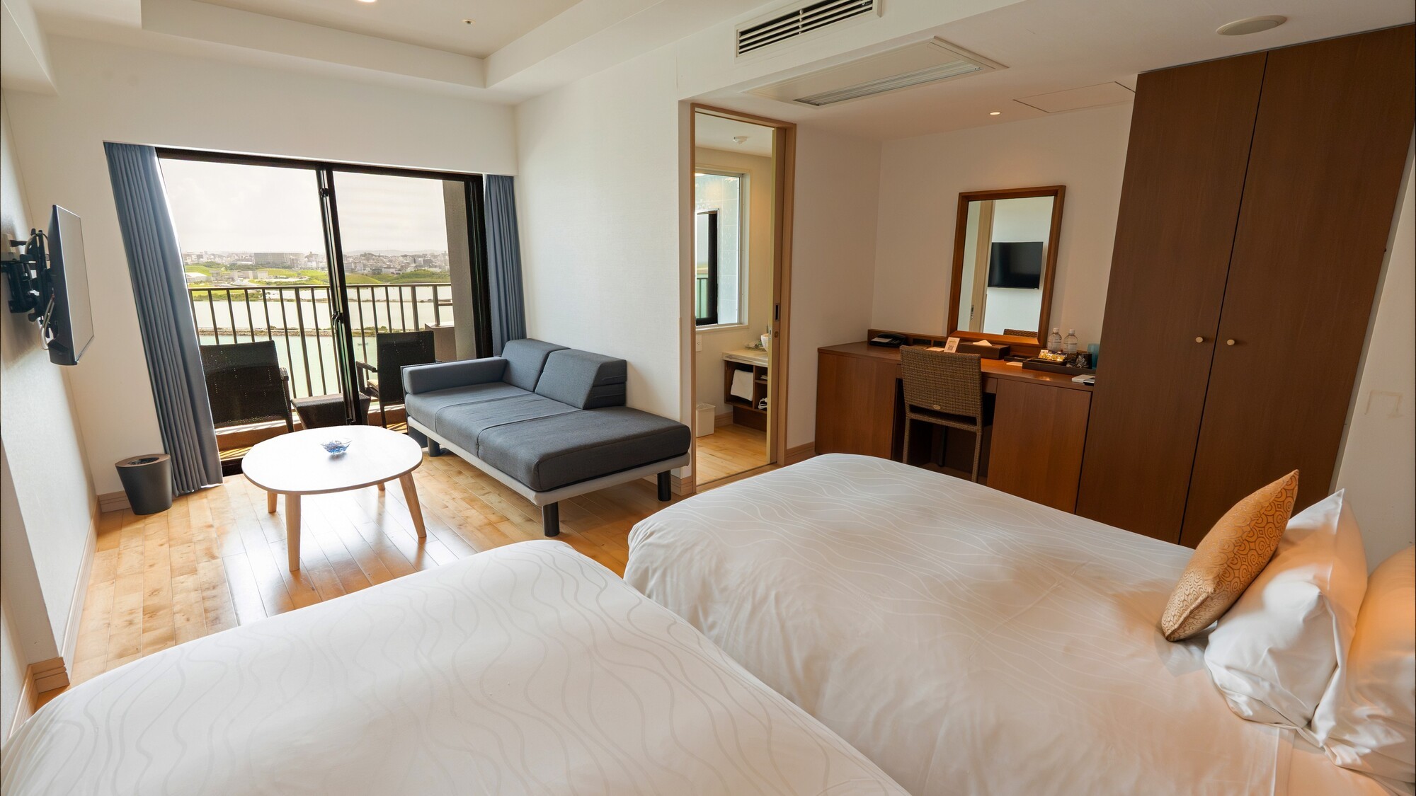 広々とした空間に、ゆったりサイズのツインベッドと寛ぎのソファを配置