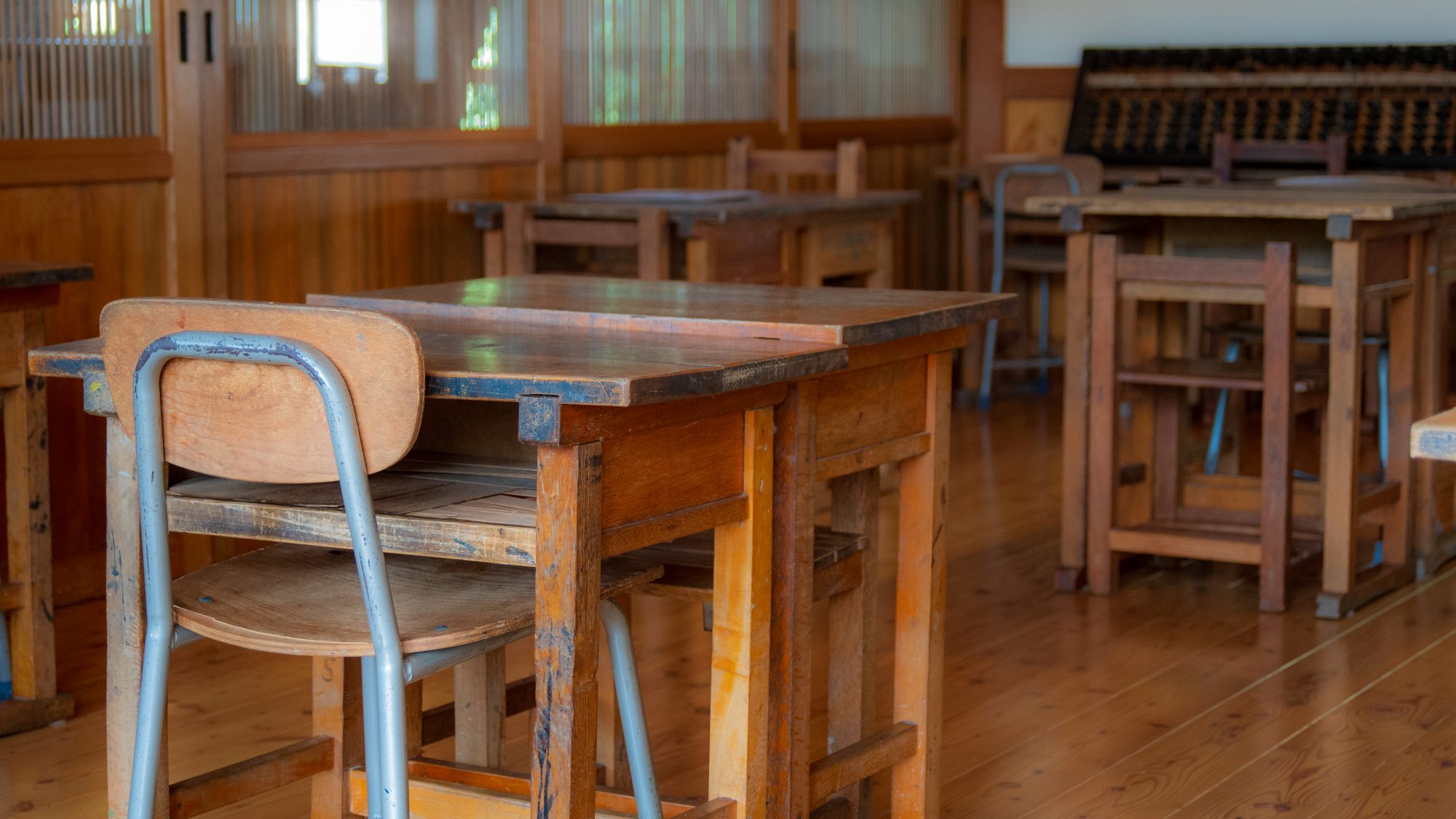 *木の机と椅子が並ぶ、どこか懐かしい昭和の教室空間