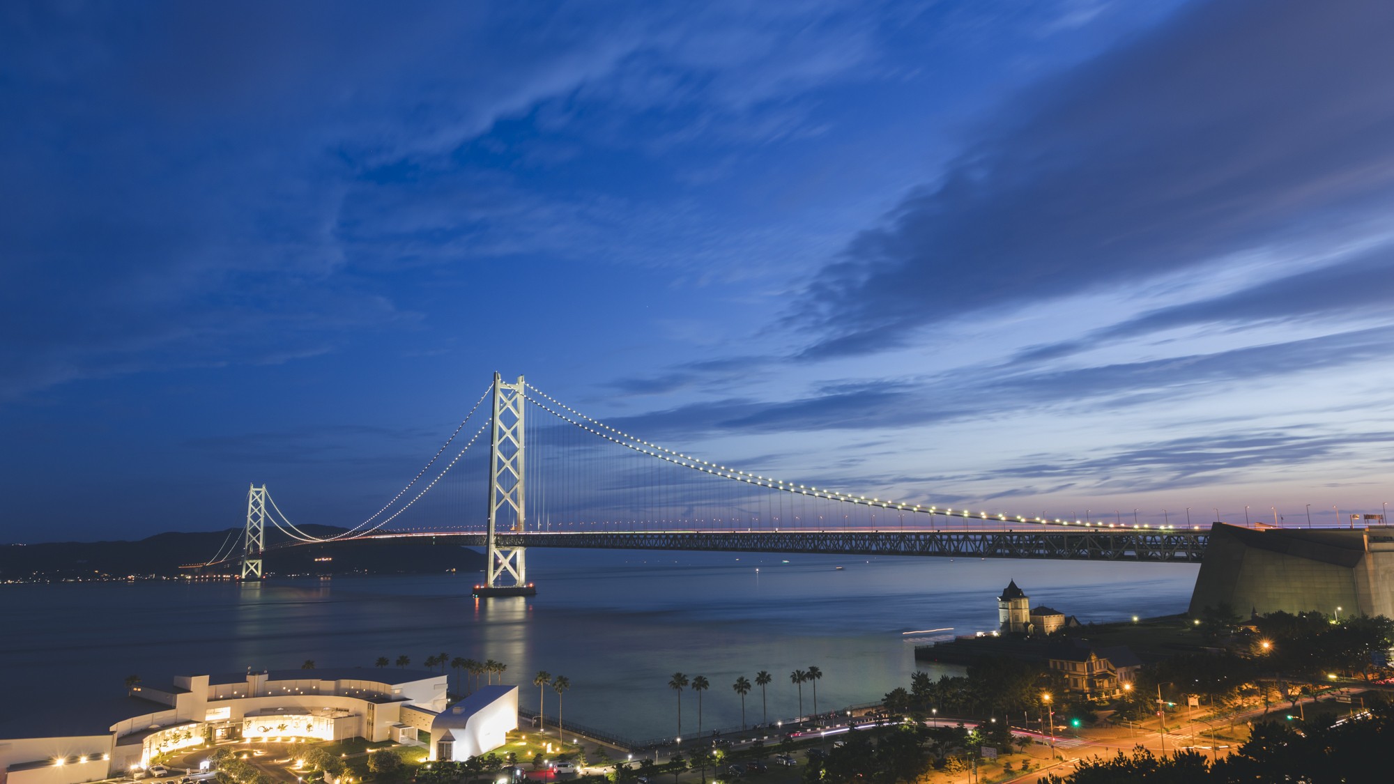黄昏時の明石海峡大橋。深い青から漆黒へと代わる海と、ライトアップされた雄姿がまた美景