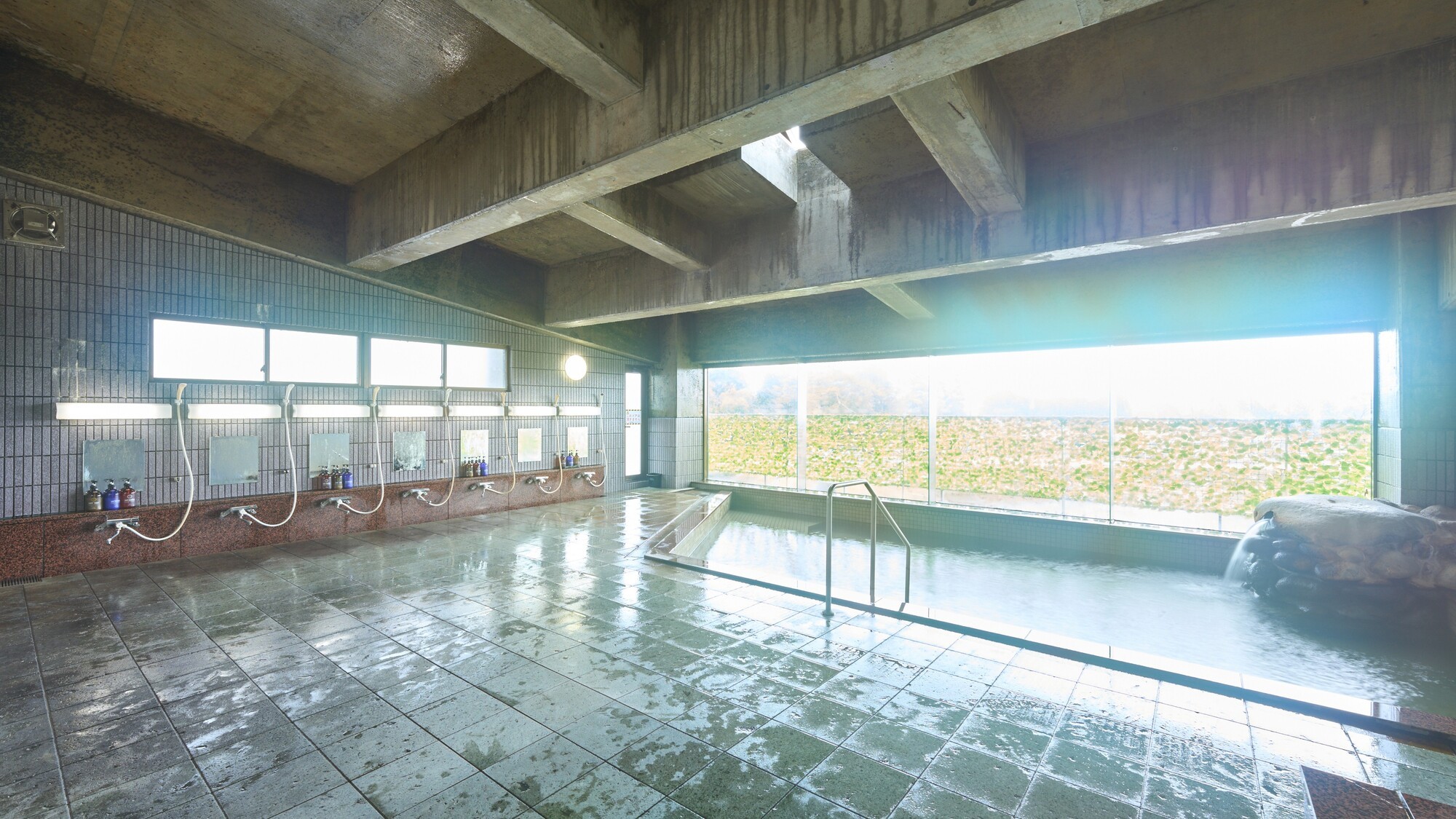 【大浴場　男湯】露天風呂、大浴場ともに、薄緑色の千貫石温泉が常にあふれ出ています。