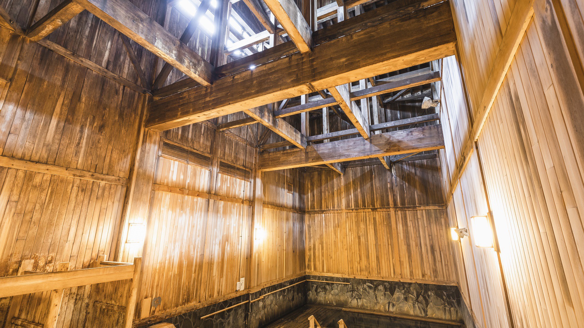 【大浴場】「泉響の湯」浴槽から梁(はり)までの高さが最頂部で12メートルと開放的な空間。