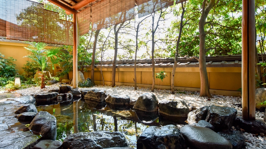 【大浴場・男湯】街中にありながら静かな当館の露天風呂は計算された木々の配置で心落ち着く造りです