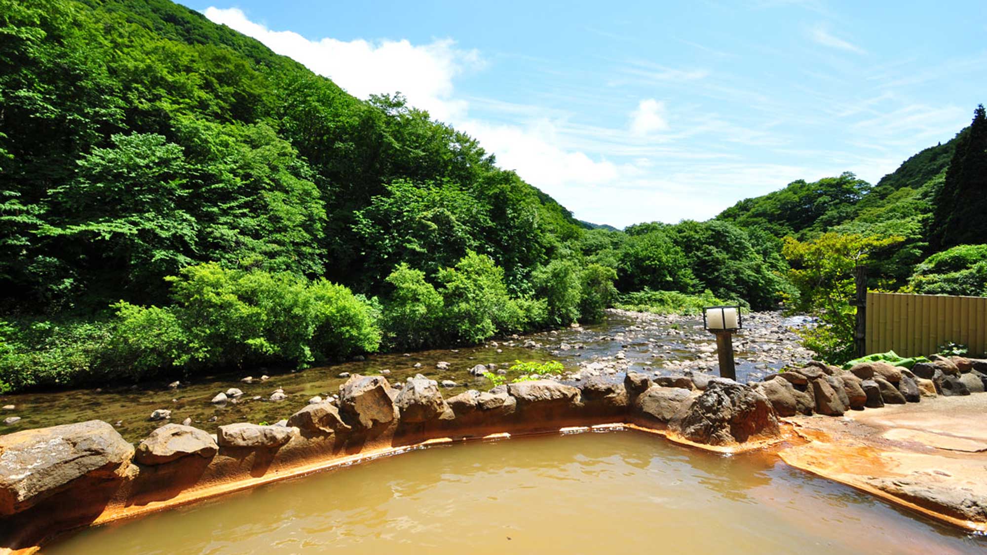 【露天風呂】男湯露天風呂。雄大な緑と川を眺めながら自然との一体感を味わえます。
