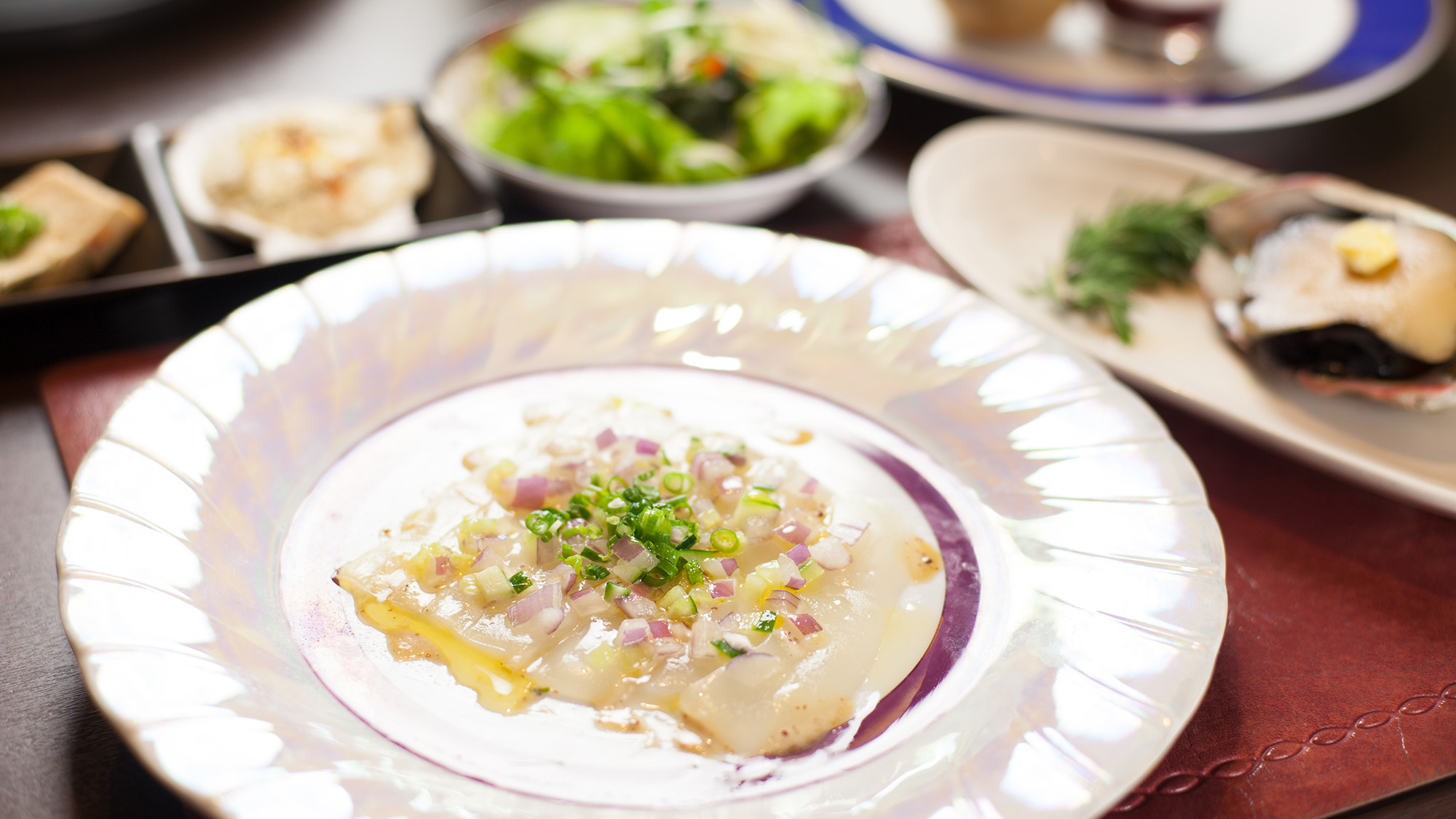 ・【鮮魚のカルパッチョ一例】オリーブオイルの香りが食欲をそそります。紫玉ねぎのアクセントも◎