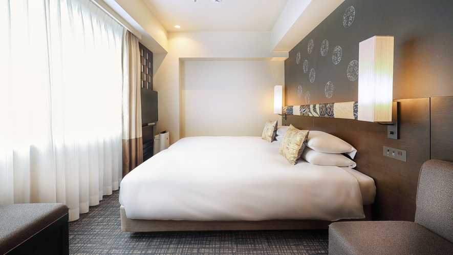 【デラックスツインルーム(23㎡)】京都らしい模様をあしらった、広めのベッドとソファが特徴のお部屋