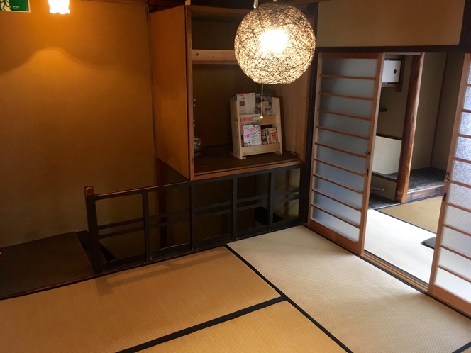 ２階共有スペースの様子。アジア風の明かりの下、京都の本やリーフレットなどがございます。