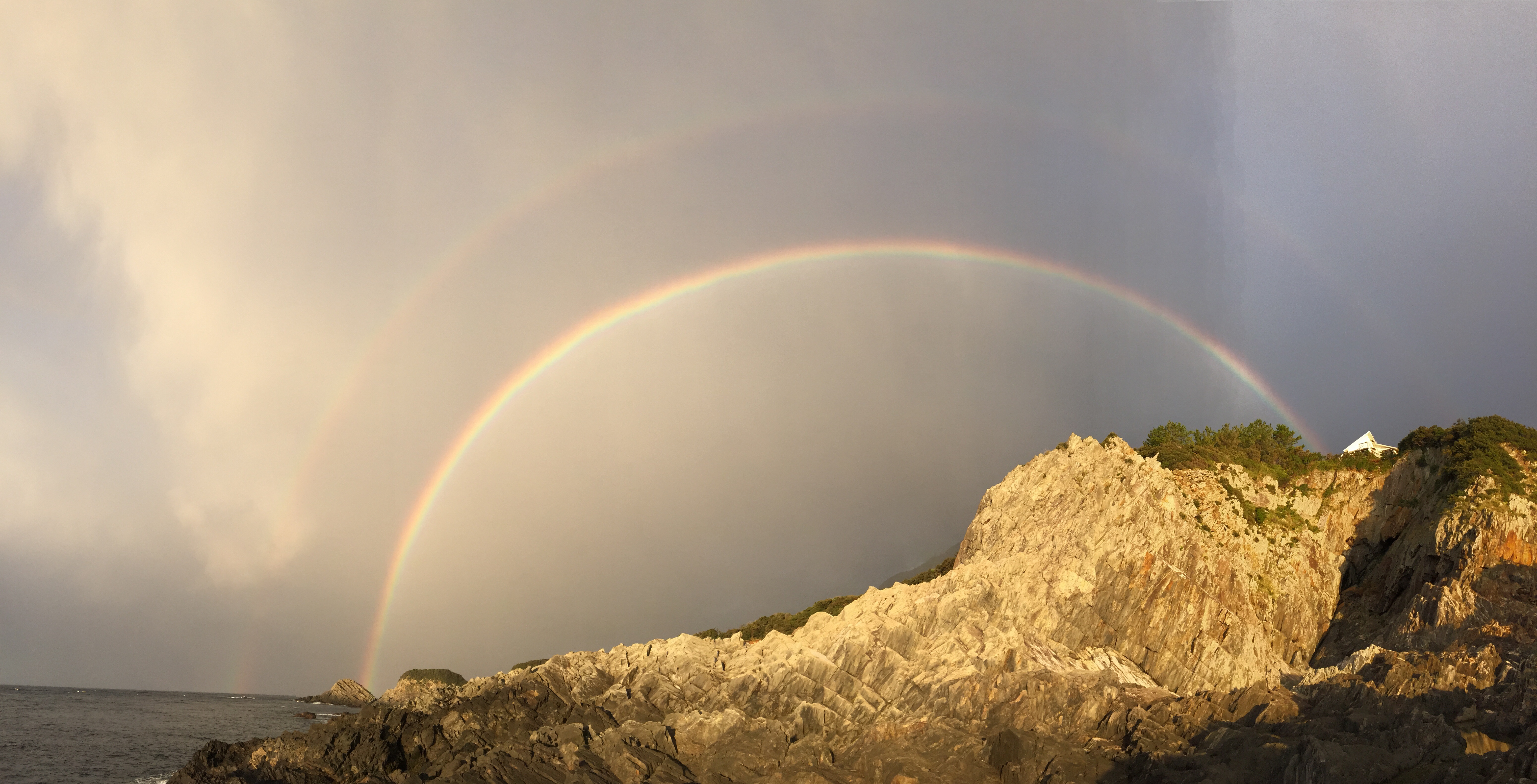 海から岩山に掛かる二重虹です。当館近くでは冬場に虹を見る機会が多いです。