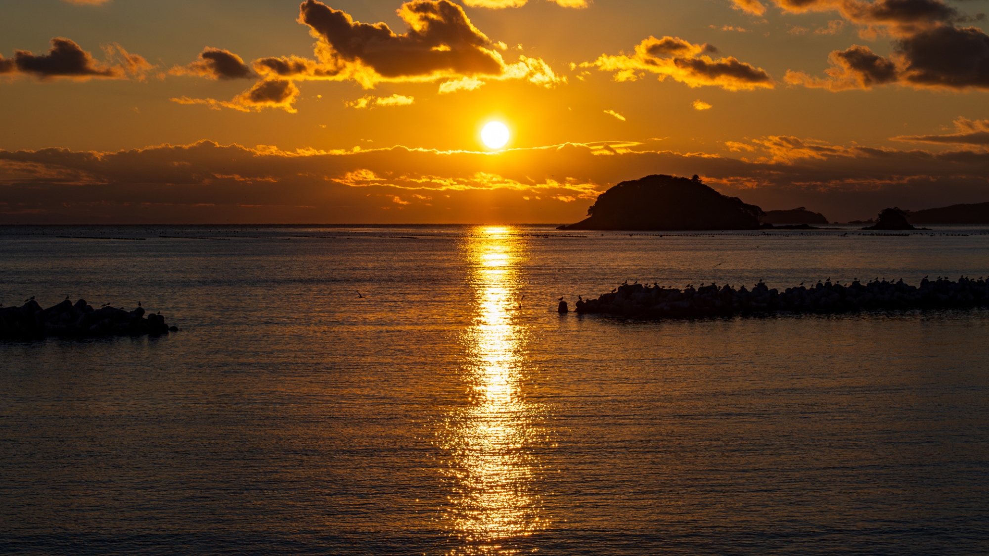 【牡鹿半島】海岸線に夕陽が沈むドラマチックな光景