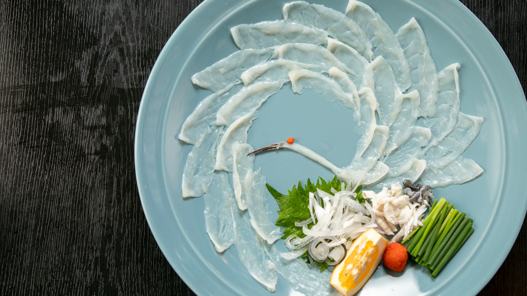 【ふぐ会席スタンダード】見た目にもこだわりを。お皿が透けるほど薄く引いた身を美しく。