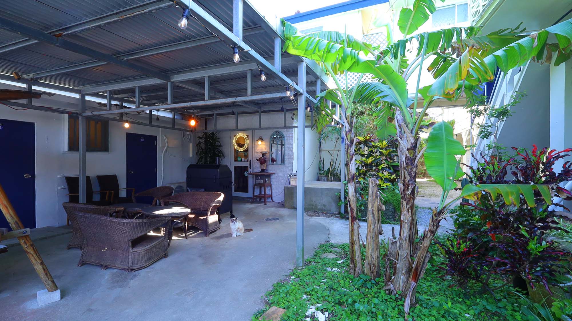 【パブリックスペース】緑陰が心地よい、ホテルのパブリックスペース。看板ネコが気まぐれにお出迎え。