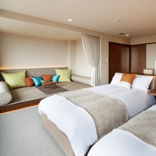 [Deluxe Room] A room with a capacity of 4 people, equipped with 2 beds and a floor sofa space.