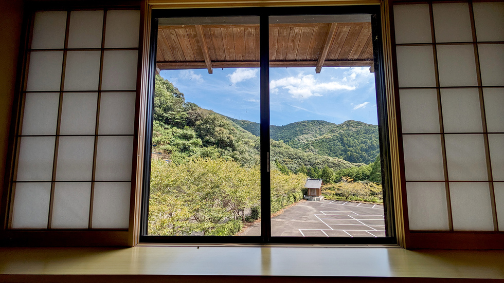 【宿泊館／和室】 窓の外に広がる山々。夜になると月や星がよく見えます。