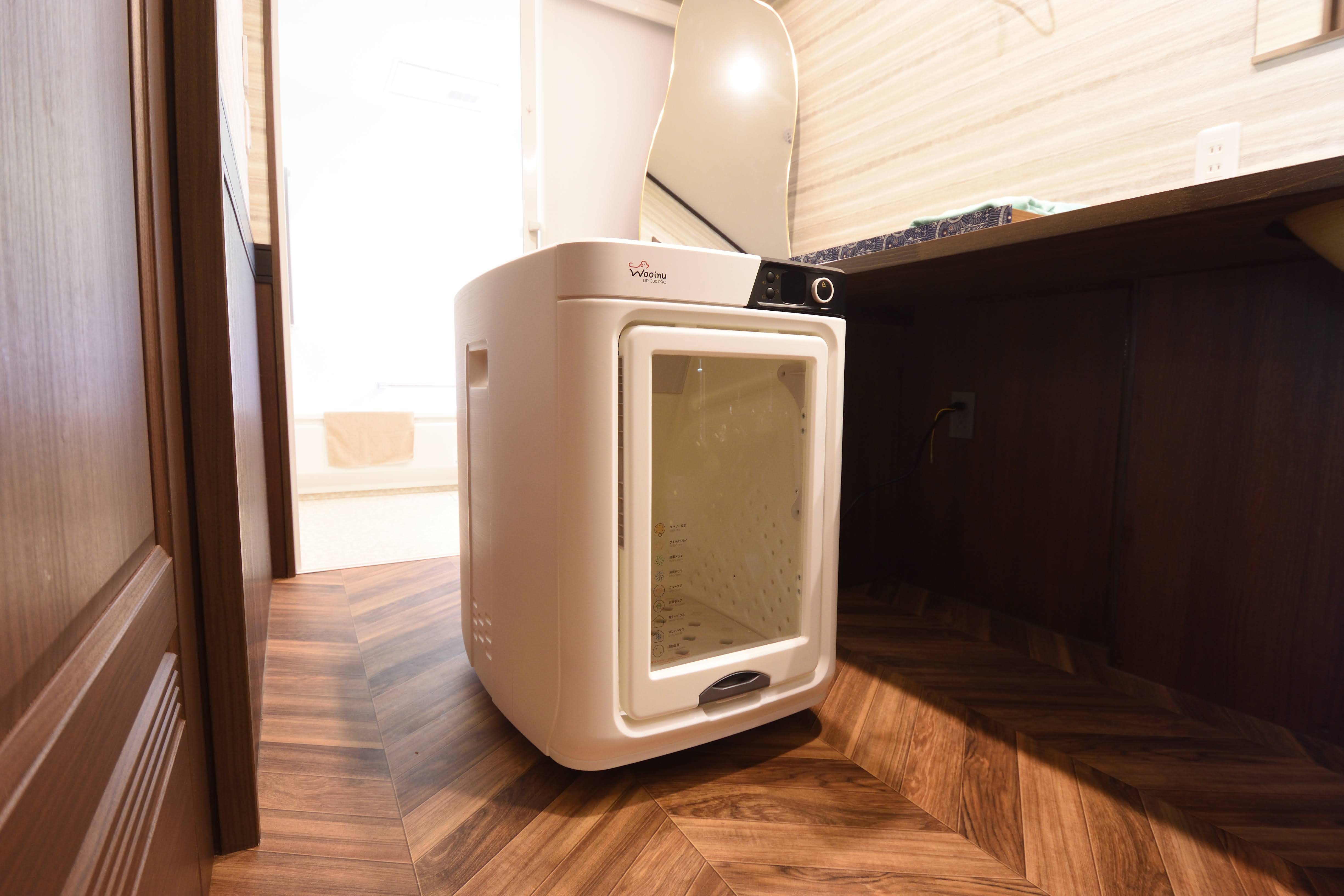 お部屋にはペット大切なペットのための高級ドライルーム「wooinu」を完備。温風とマイナスイオンでふんわり乾燥し、静音設計で快適。被毛を優しくケアしながら、時短＆ストレスフリーなお手入れを実現します。